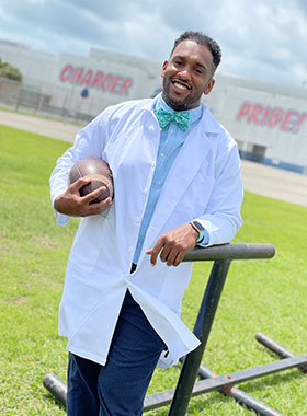 North Miami Beach Orthodontist hold a football